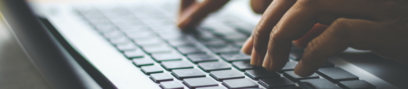 a hand typing on a computer keyboard