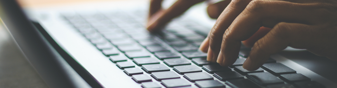 a hand typing on a computer keyboard